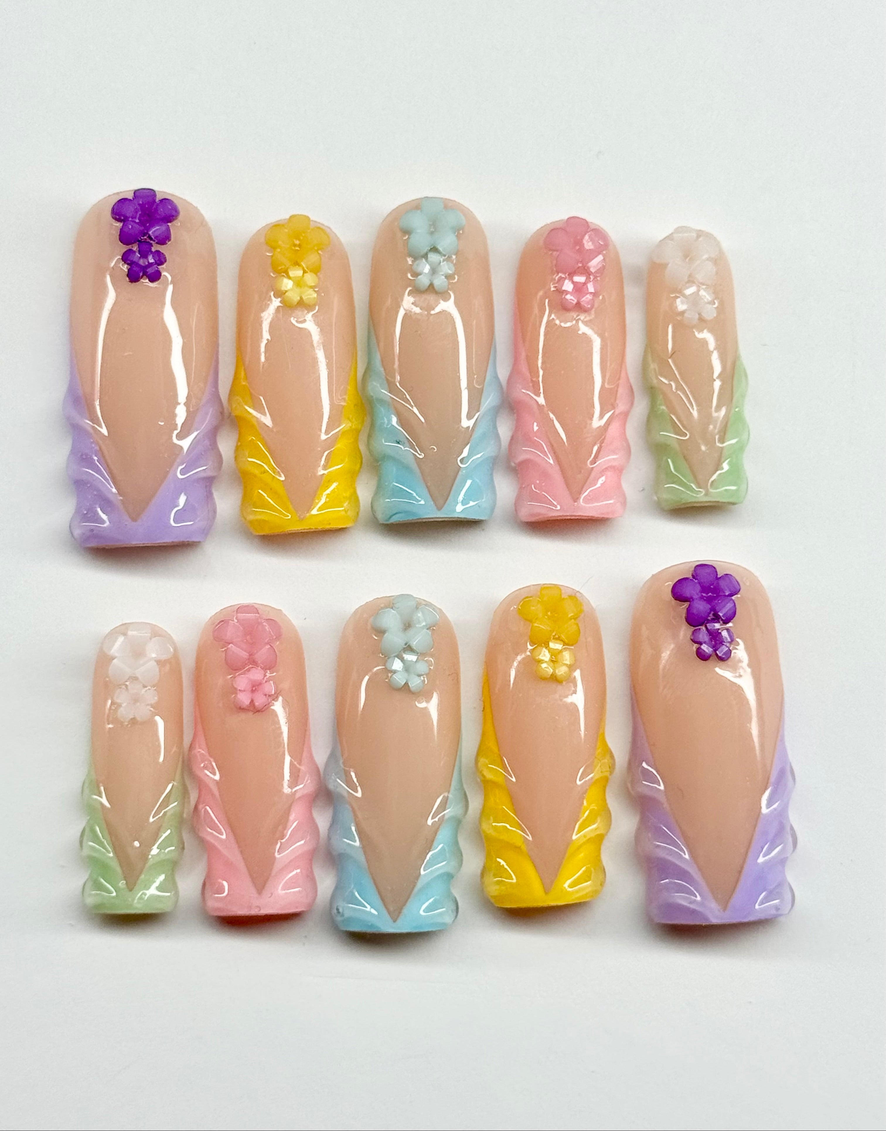 Set of pastel-colored nail art designs on a white background