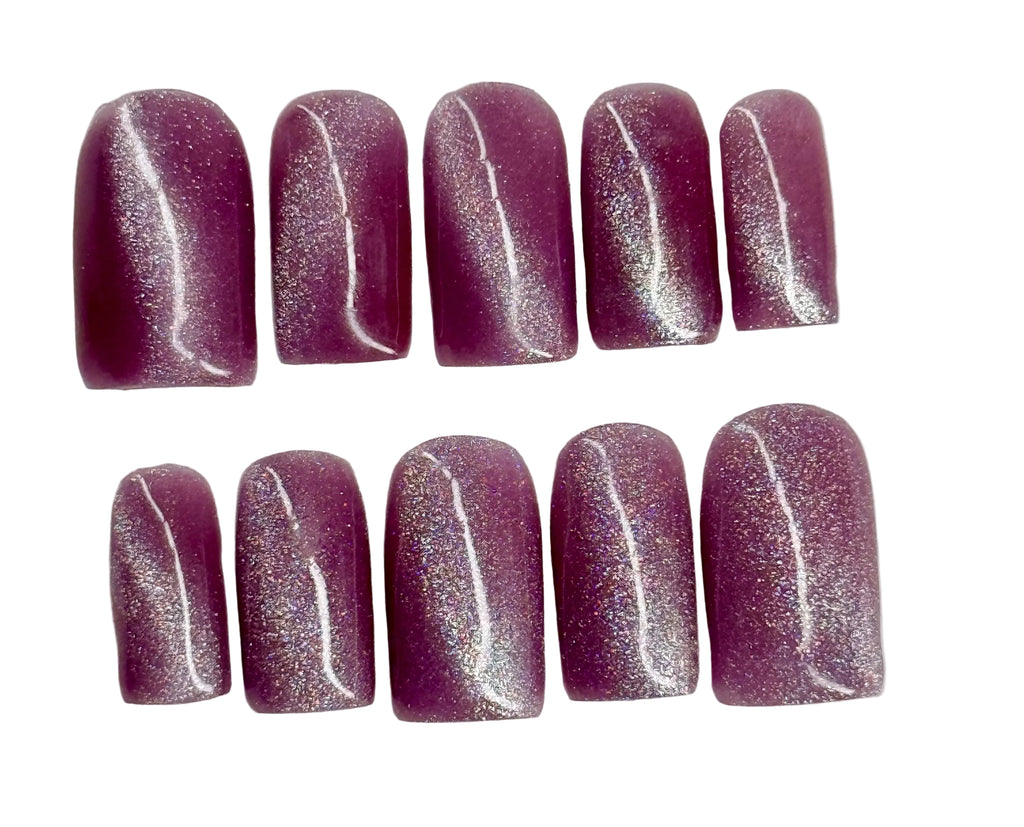 Row of purple glittery nail polish on a white background