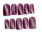 Row of purple glittery nail polish on a white background