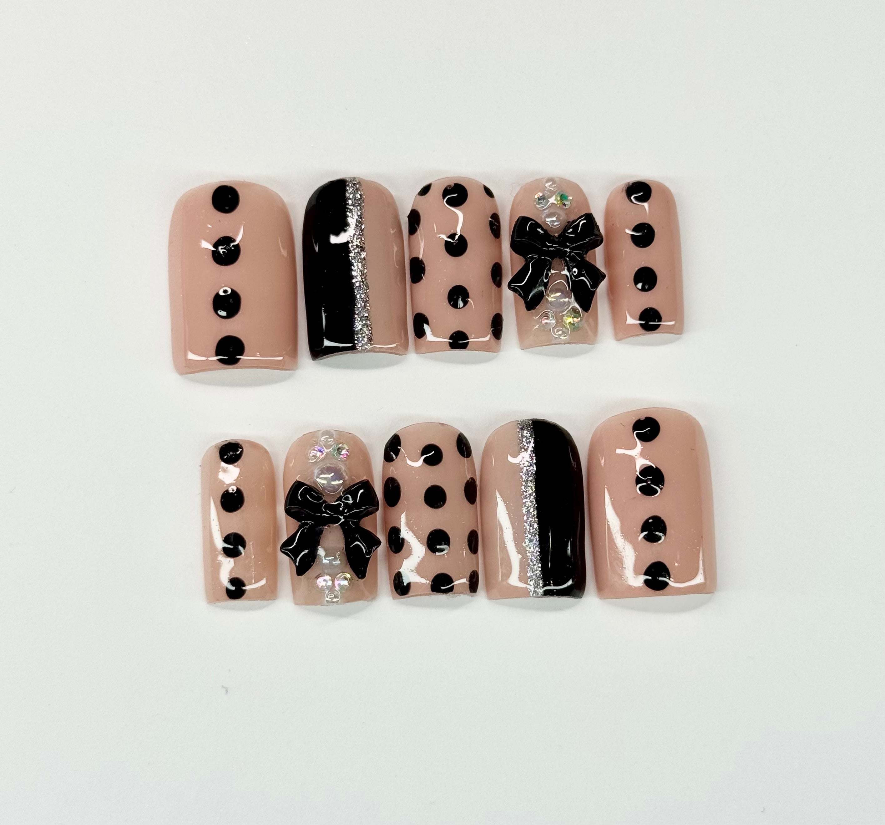 Set of nail art designs with polka dots and bows on a light background