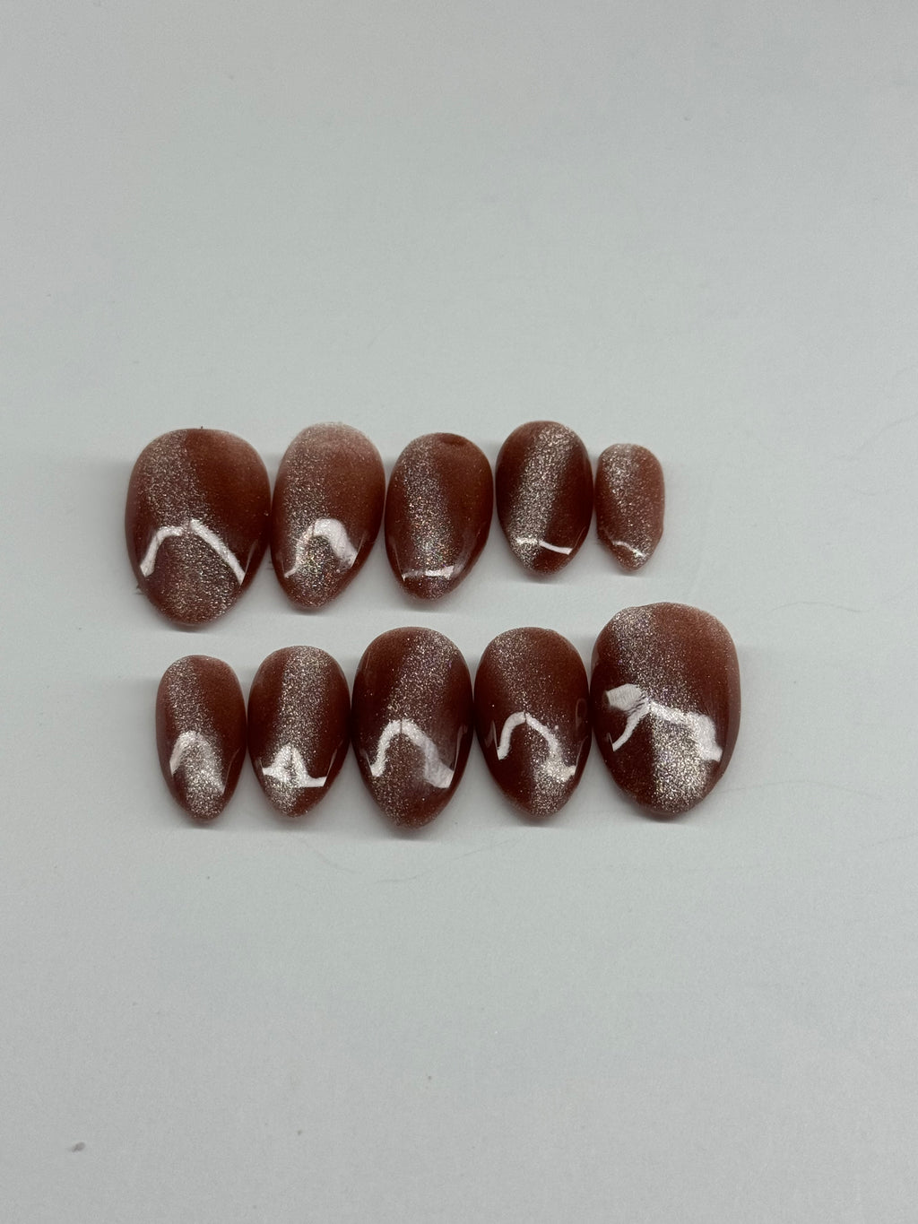 Chocolate candies with white swirls on a light gray background
