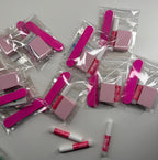 Pink and white items in clear packaging on a white surface