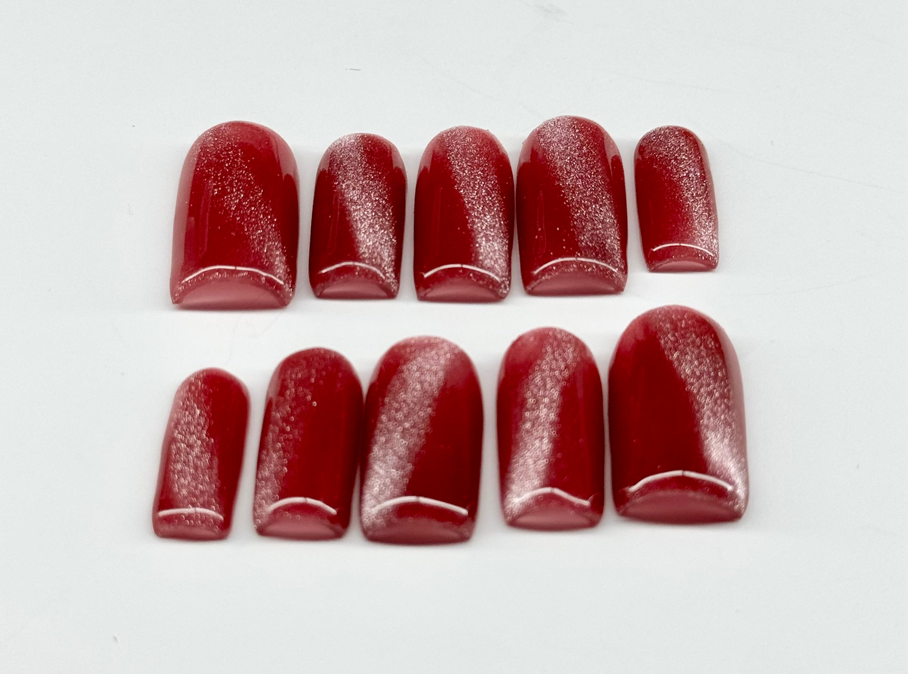 Set of dark pink nail polish samples on a white background