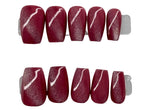 Set of red nail art with white designs on a branded card