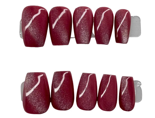 Set of red nail art with white designs on a branded card