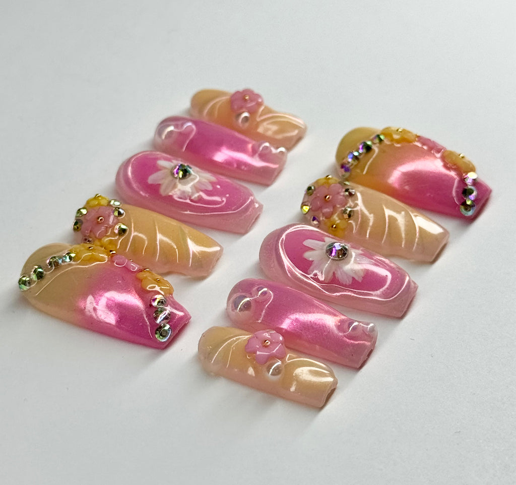Set of pink and beige nail art designs with decorative elements on a white background