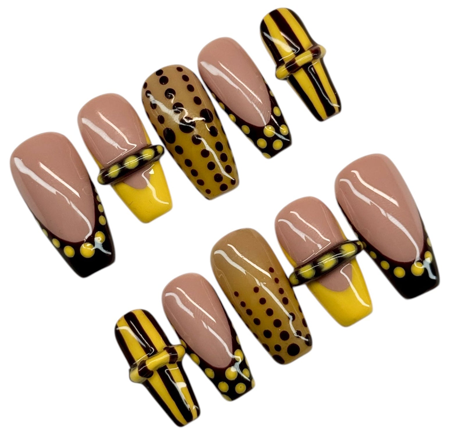 Set of false nails with brown, yellow, and black designs on a white background