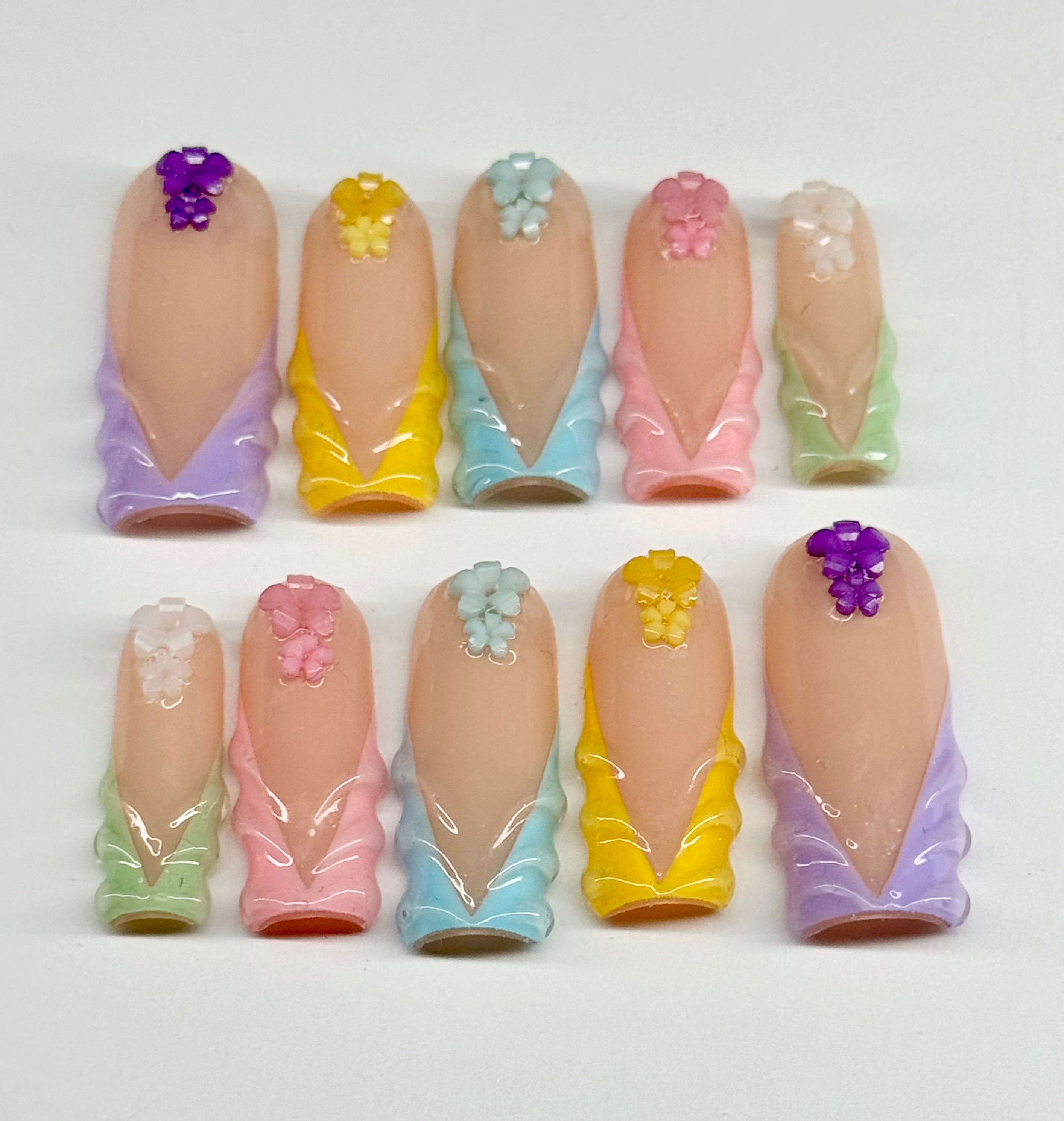 Set of pastel-colored nail art designs on a white background