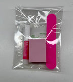 Packaged nail care items including a pink nail file, white box, and red tube on a gray background.