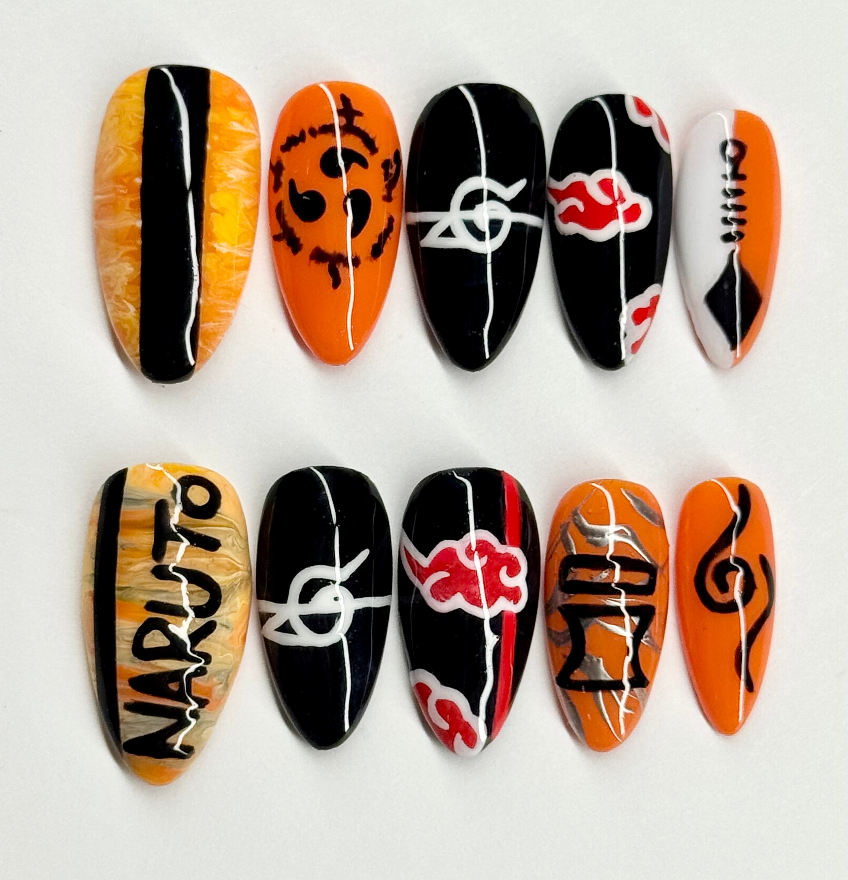 Nail art designs inspired by Naruto with black, orange, and white patterns on a white background.