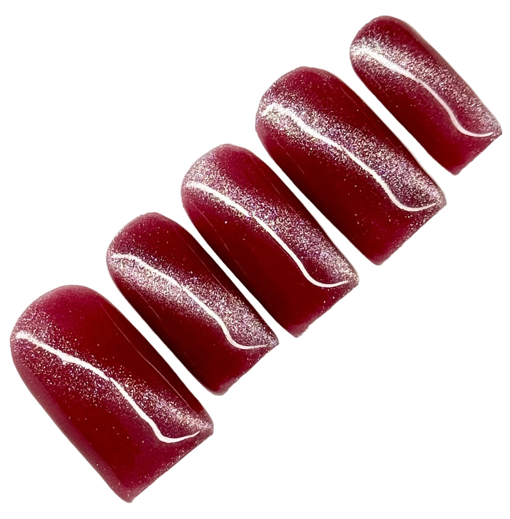 Set of dark pink cat eye nail polish with glitter on a white background