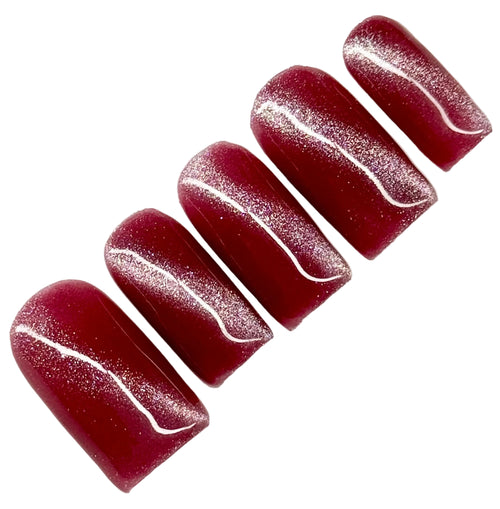 Set of dark pink cat eye nail polish with glitter on a white background