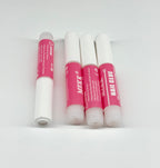 Four tubes of nail glue with pink caps on a white background