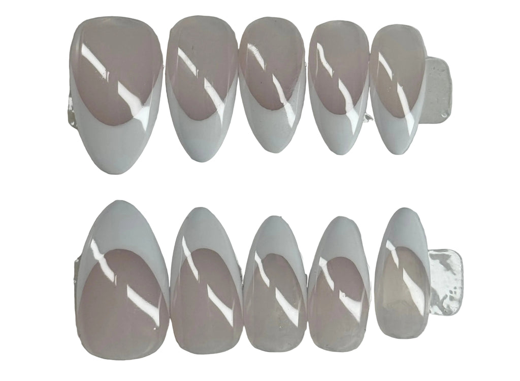 Set of clear nail extensions on a gray background