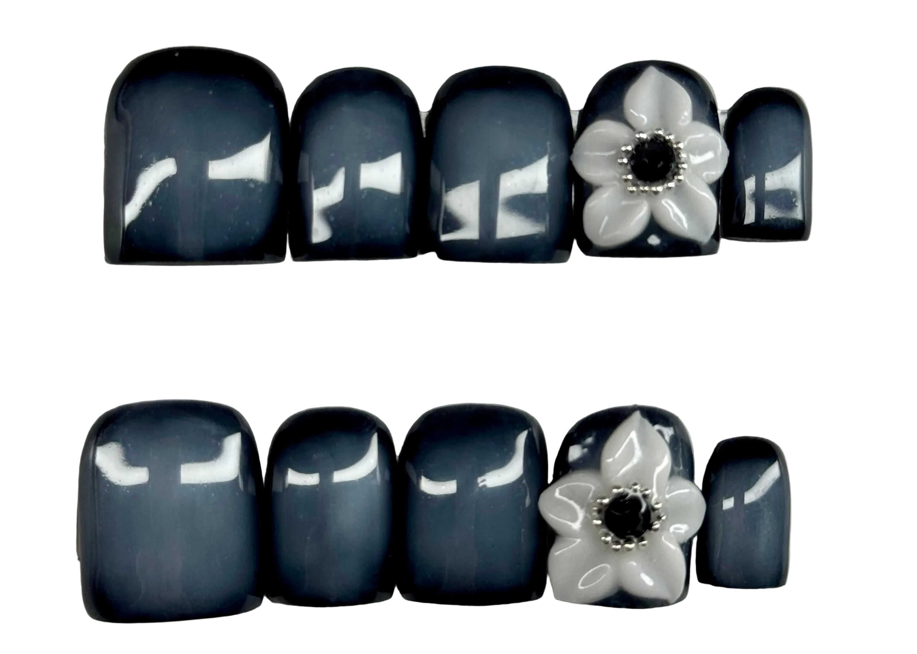 Nail art with black and white flowers on a light gray background
