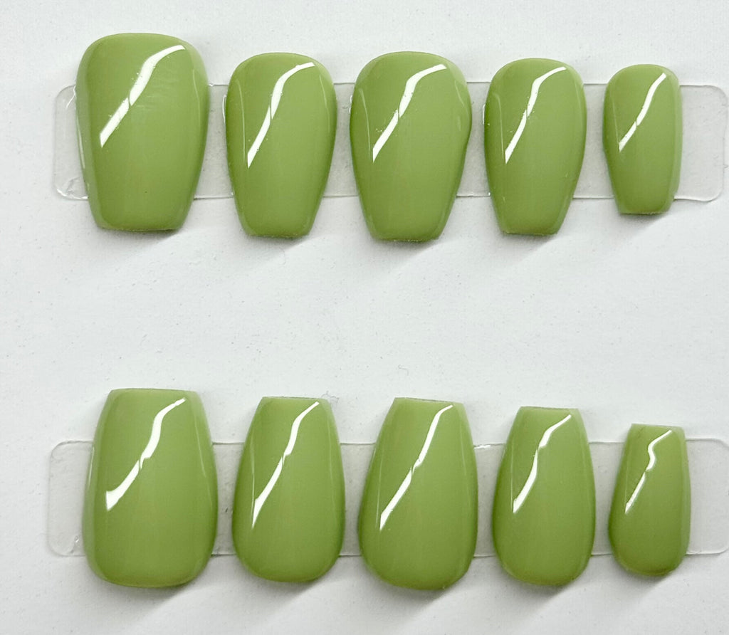 Set of green press-on nails with white lines on a white background
