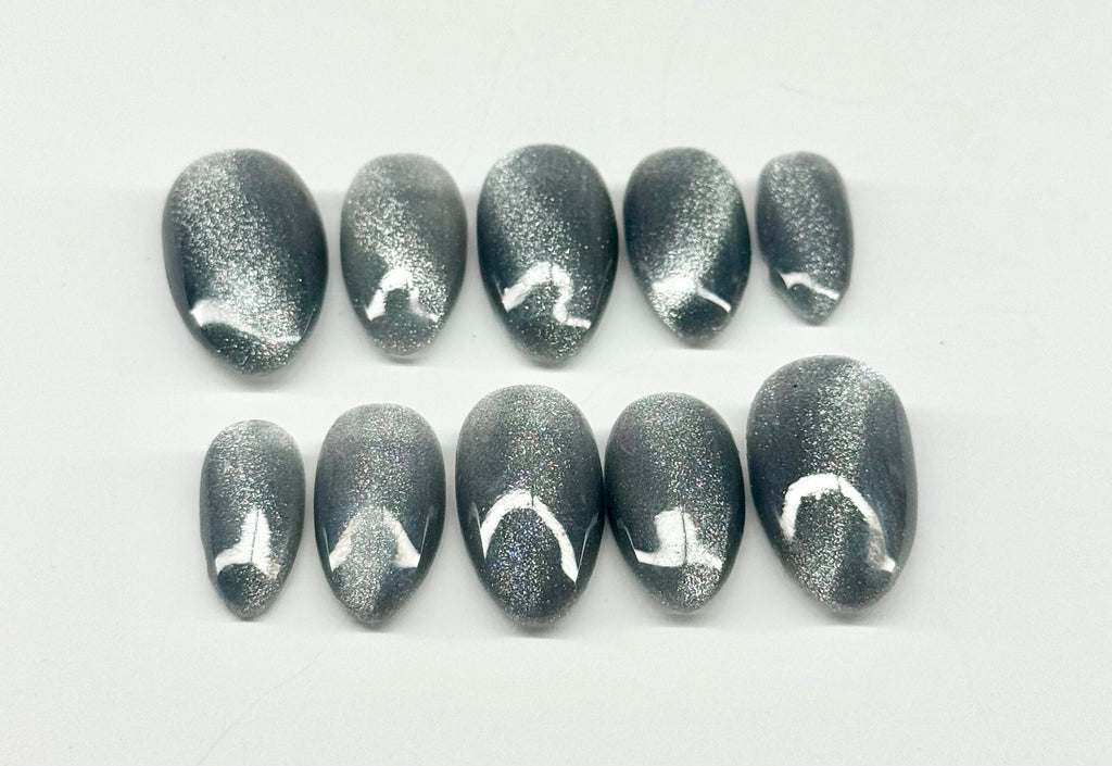 Row of gray glittery nail art designs on a white background