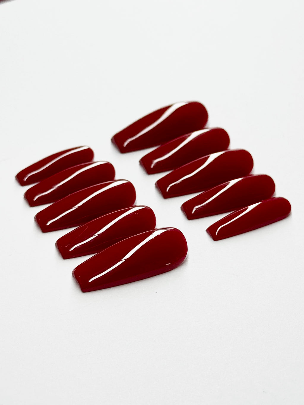 Red nail polish strips on a white background