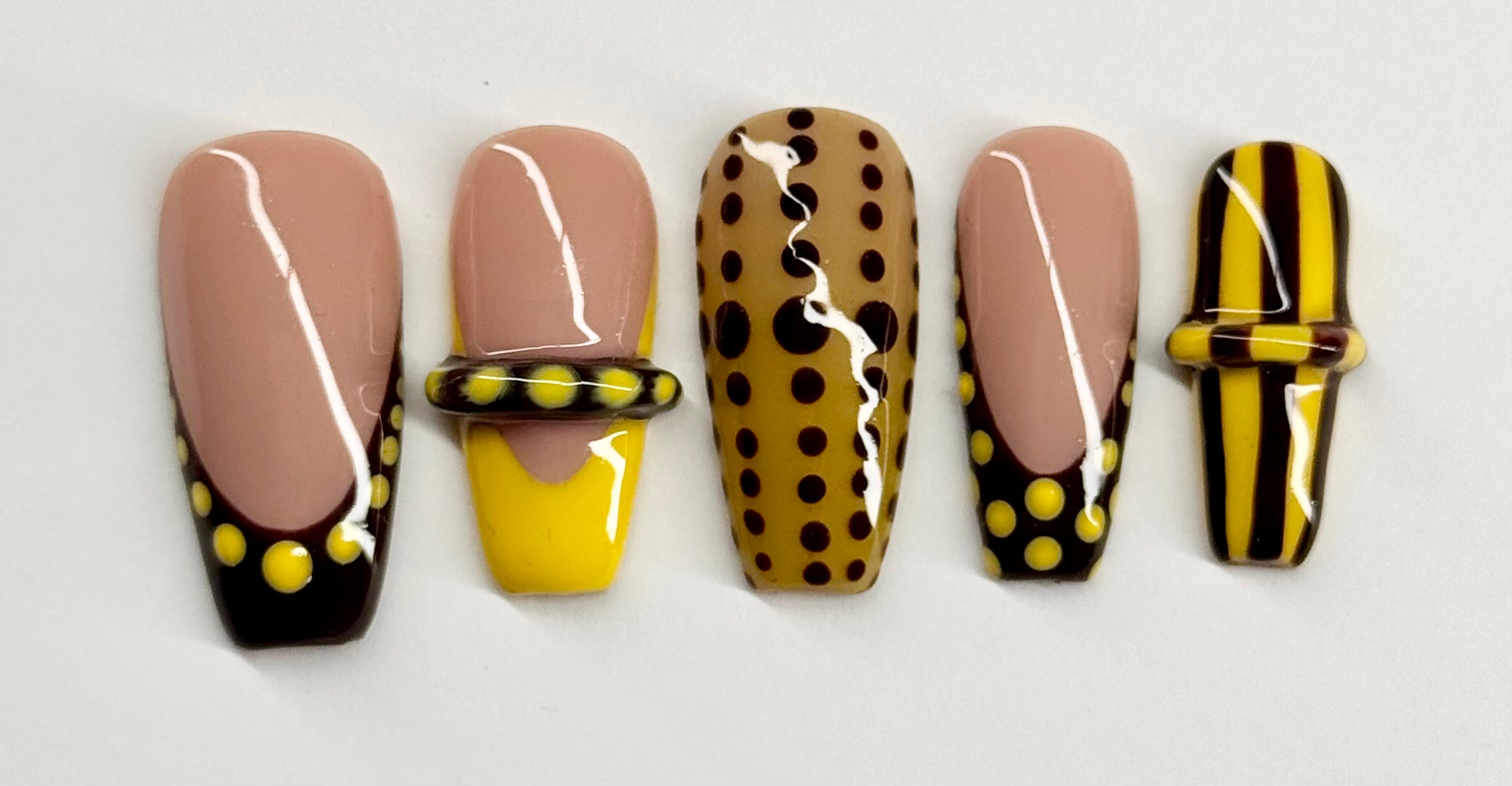 Set of five nail art designs with polka dots and stripes on a white background