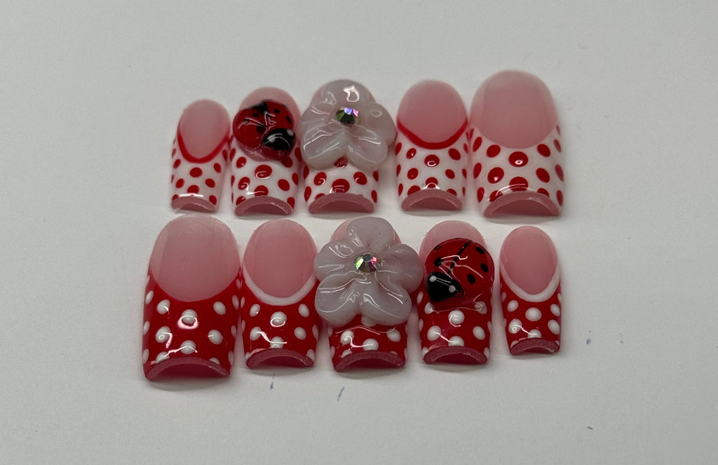 Set of red and white polka dot nail art stickers on a white background