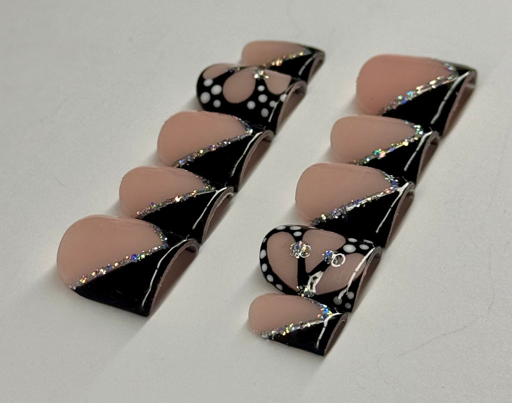 Pair of black and beige earrings on a light gray background