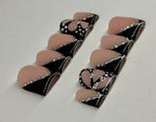 Pair of black and beige earrings on a light gray background