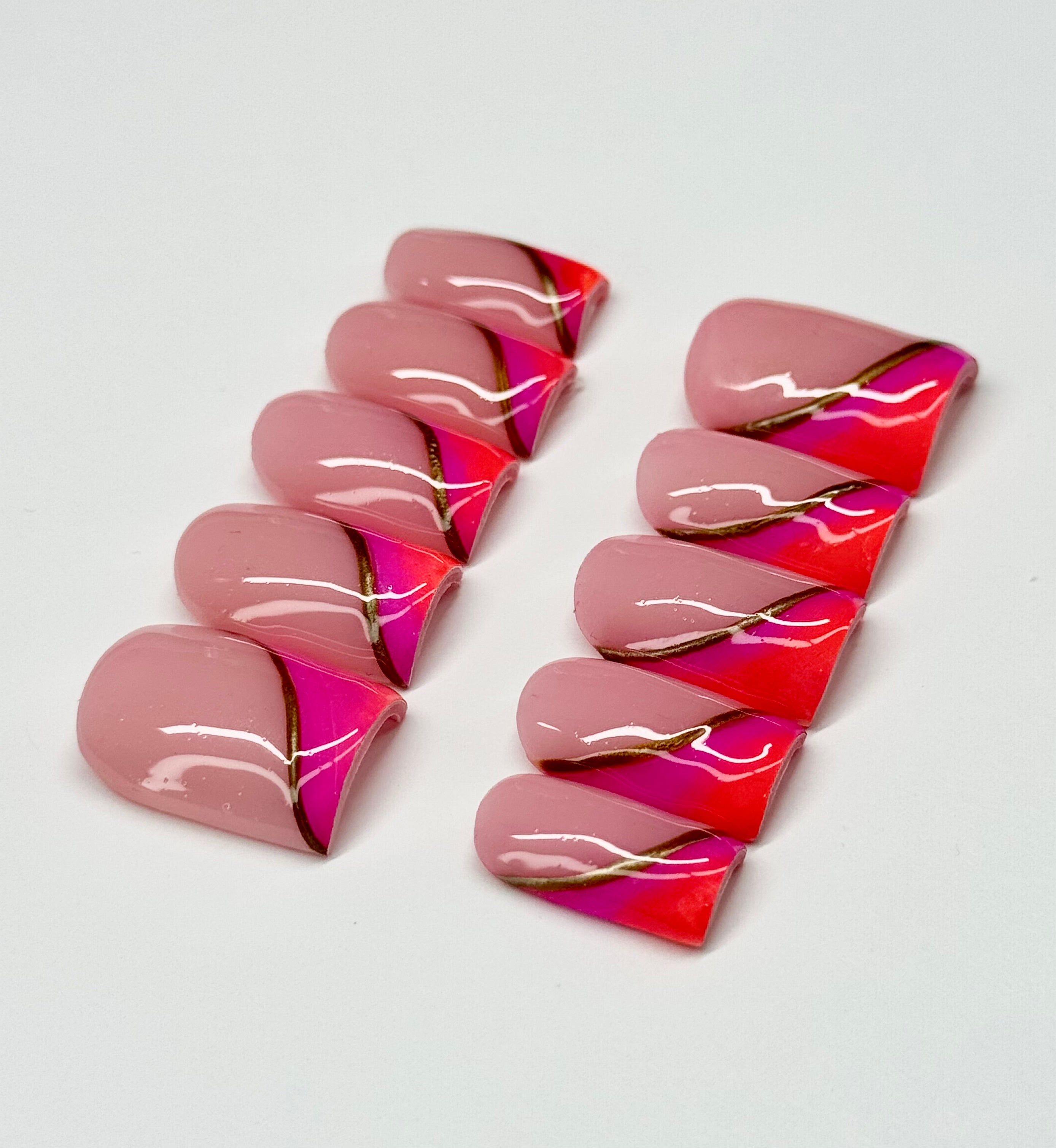 Pink and orange nail art designs on a white background