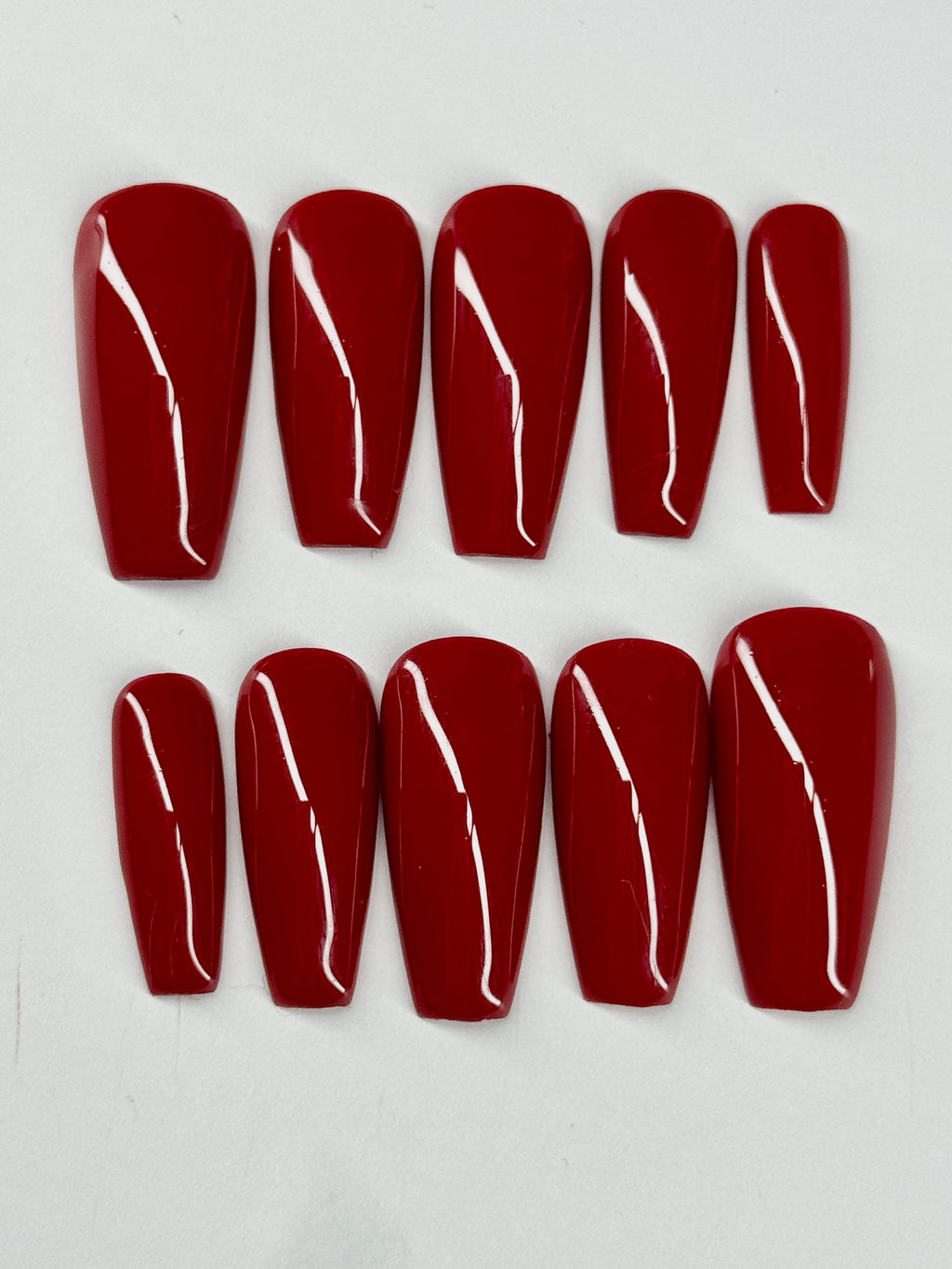 Set of red nail extensions on a white background