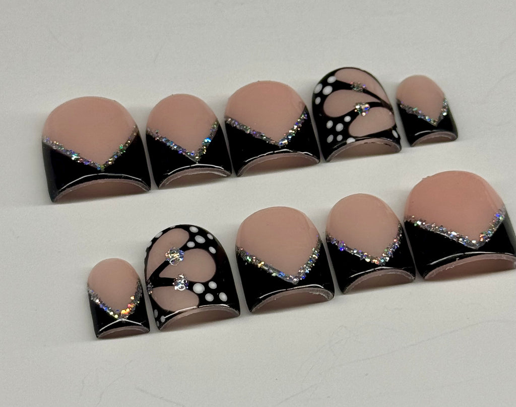 Set of nail art designs with black, white, and beige colors on a white background