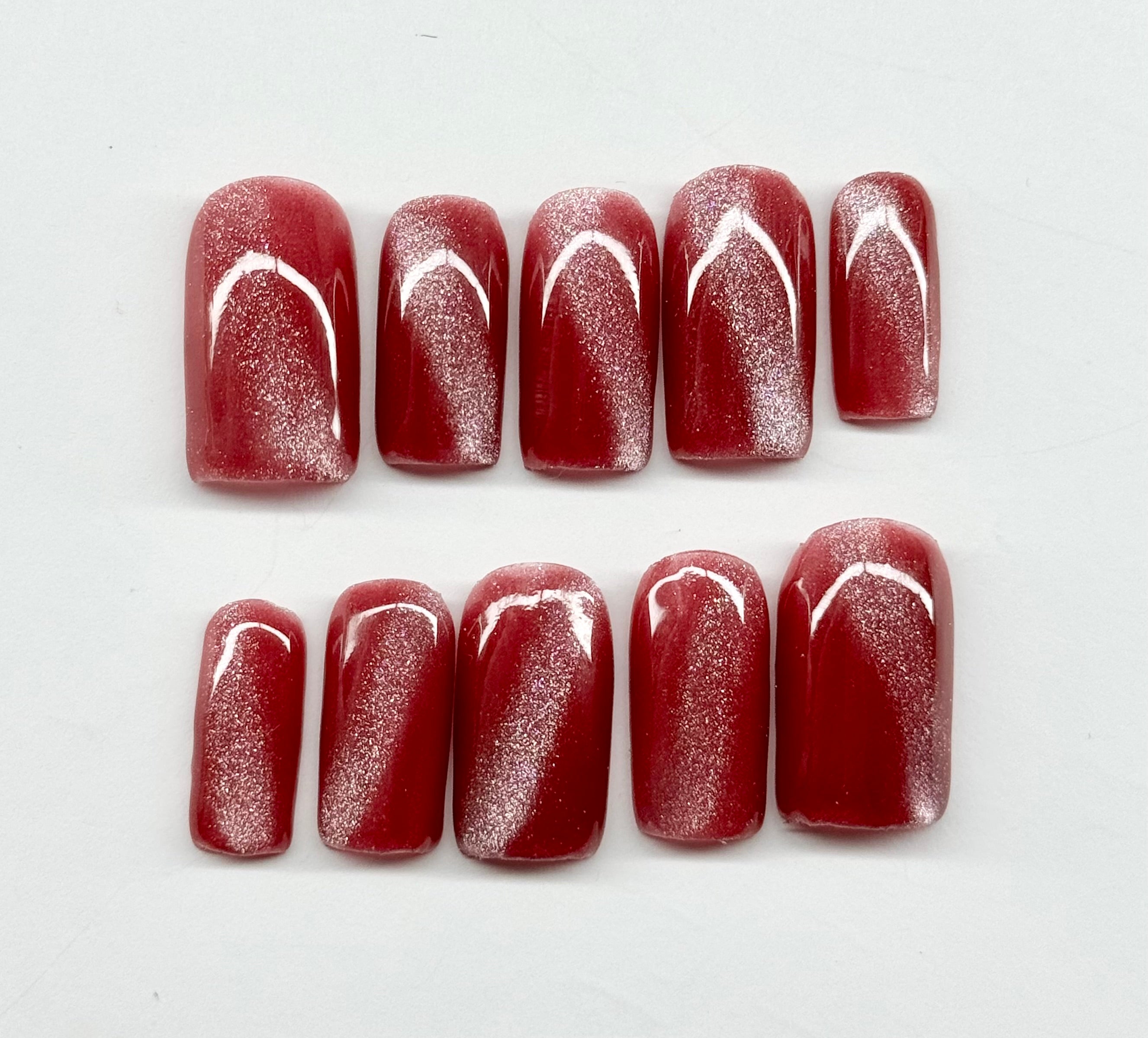 cat eye nail polish with white designs on a white background