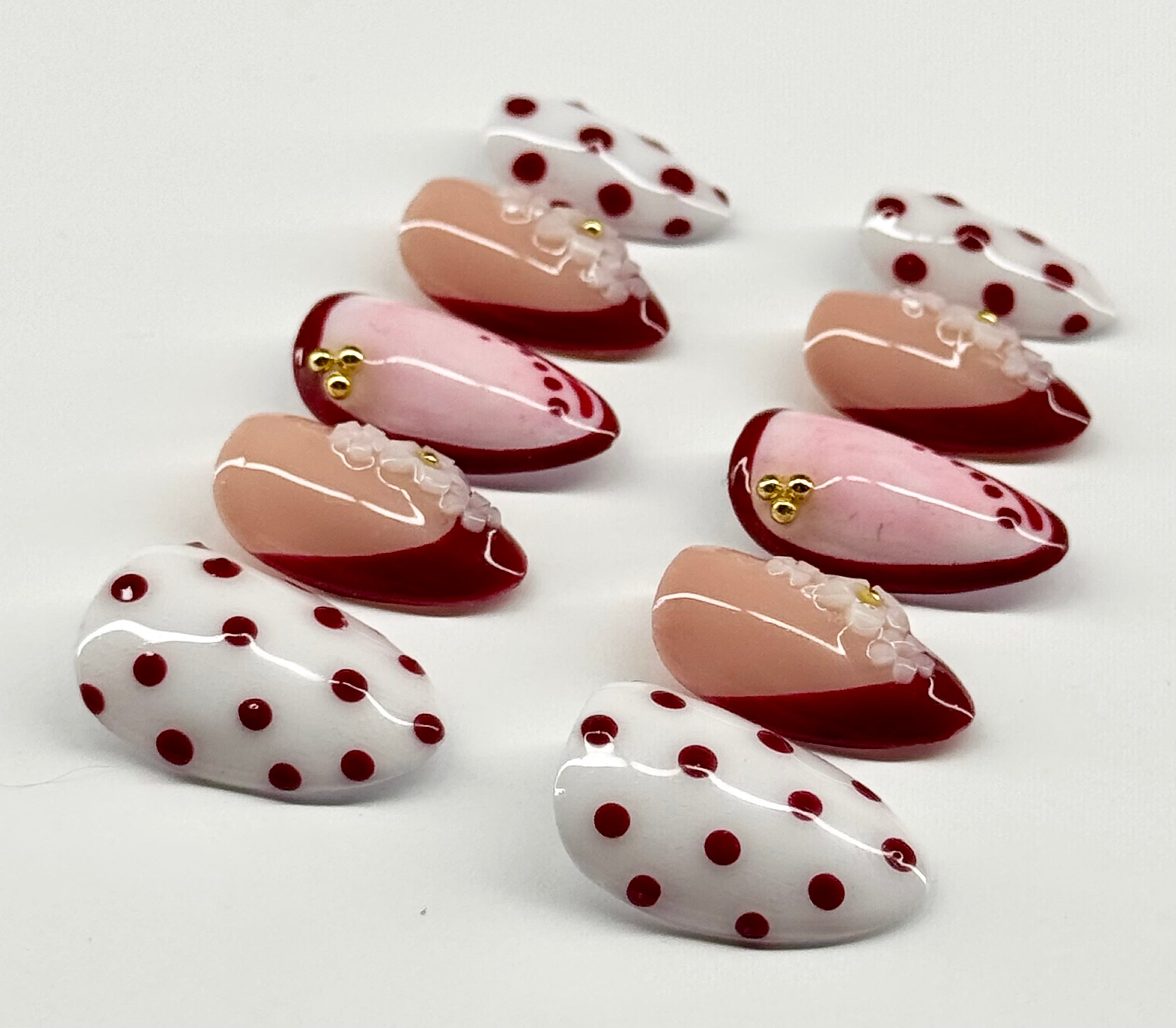 Set of artificial nails with polka dot design on a white background