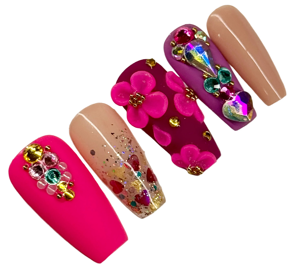 Decorative nail art with flowers and gemstones on a white background
