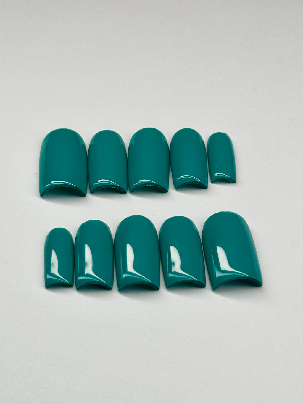 Teal nail polish strips on a light gray background