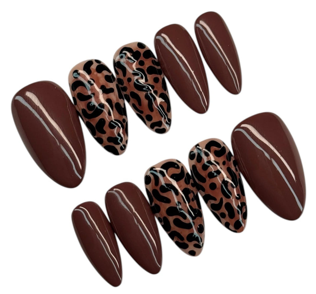 Set of brown press-on nails with leopard print design on a white background