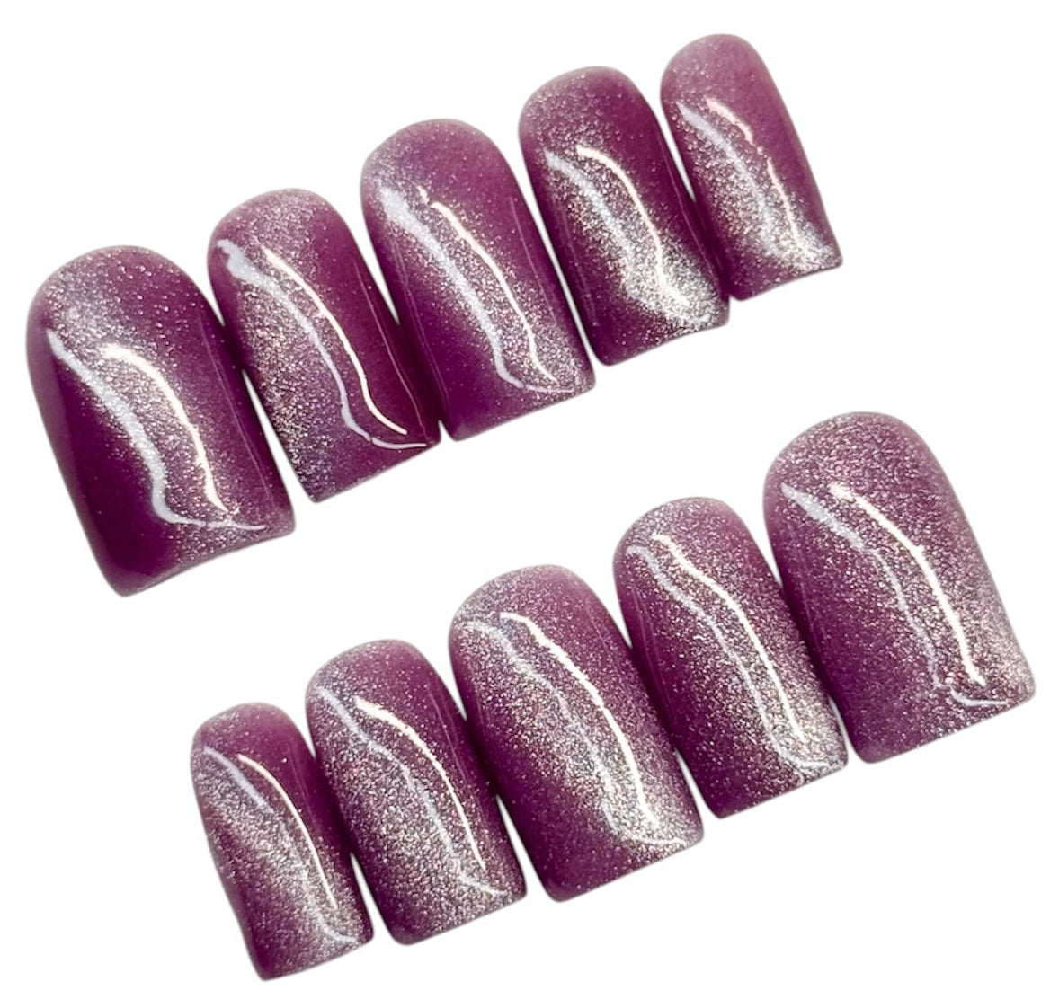 Set of purple cat eye glittery nail art on a white background