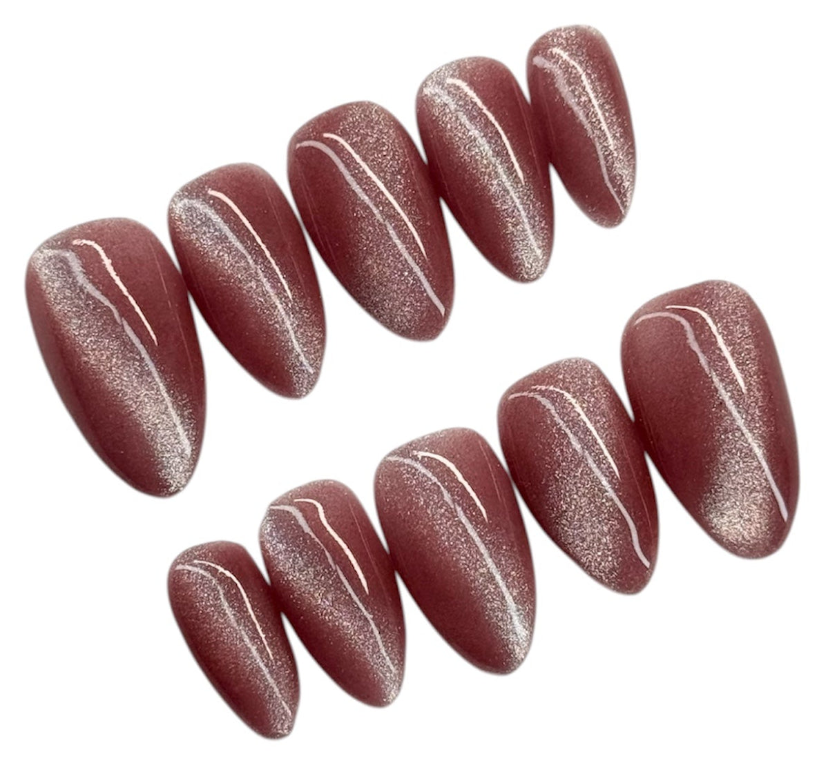 Set of light pink cat eye glittery nail art decorations on a white background