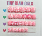Set of pink hair accessories with polka dots and bows on a 'Tiny Glam Girls' branded card.