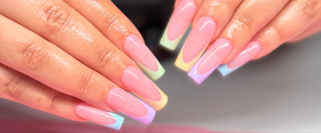 Close-up of hands with pastel nail polish on a blurred background