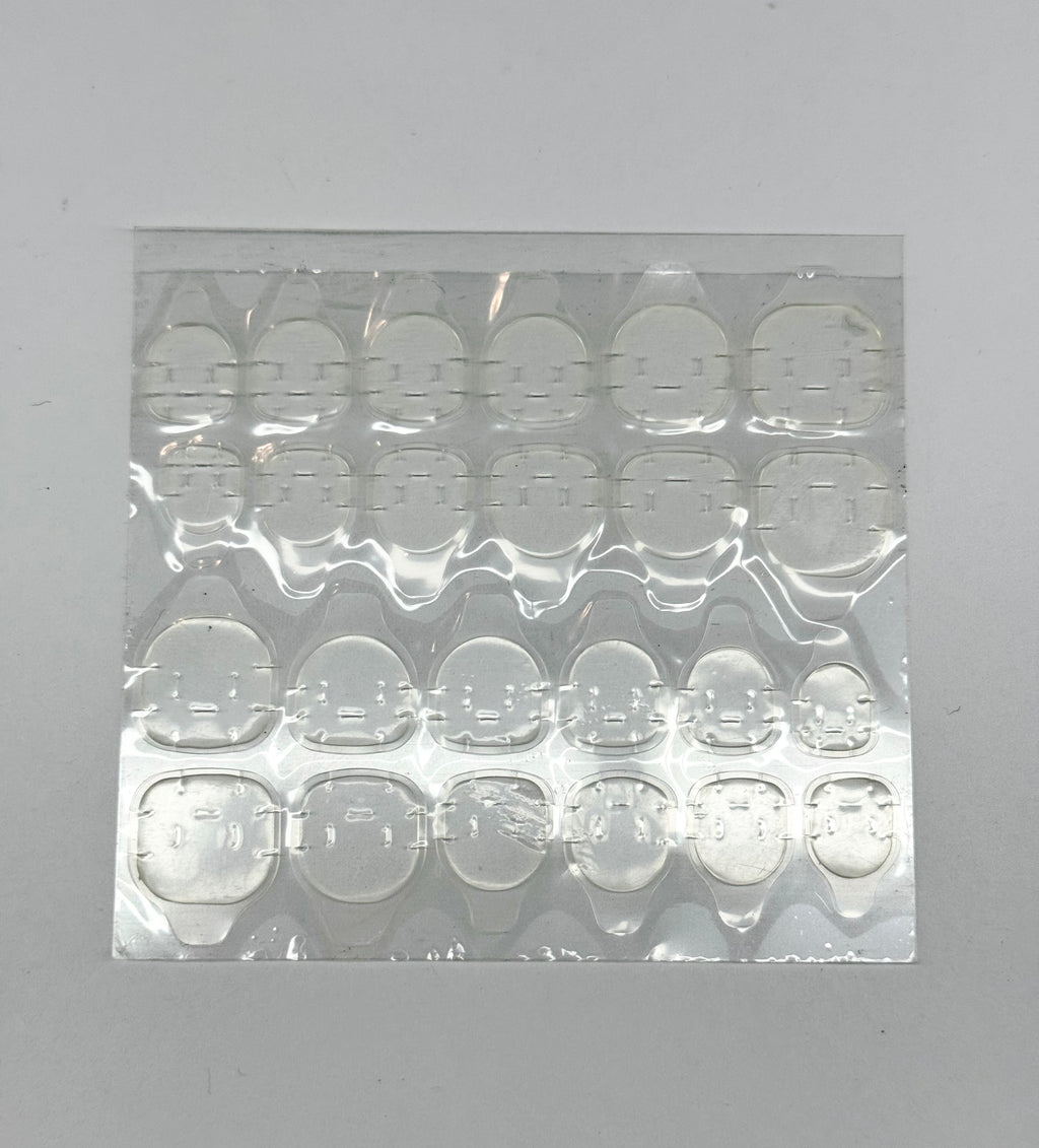 Sheet of clear adhesive patches on a gray background