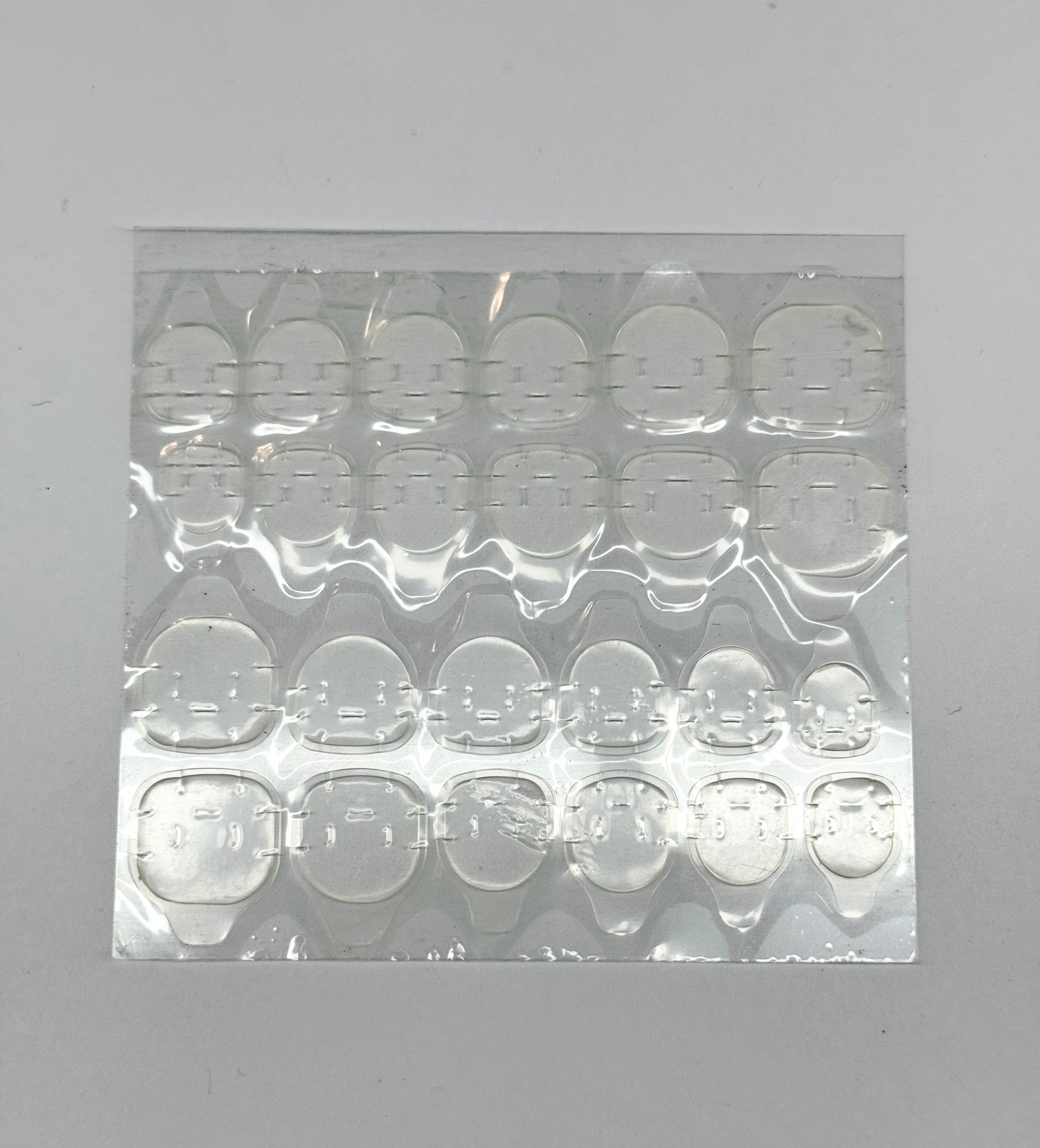 Sheet of clear adhesive patches on a gray background